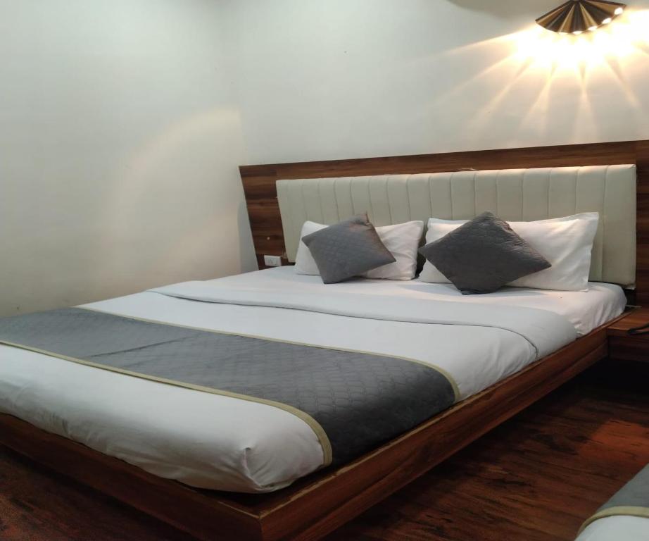 a bedroom with a large white bed with two pillows at HOTEL AIR VIEW Near Airport in Mumbai