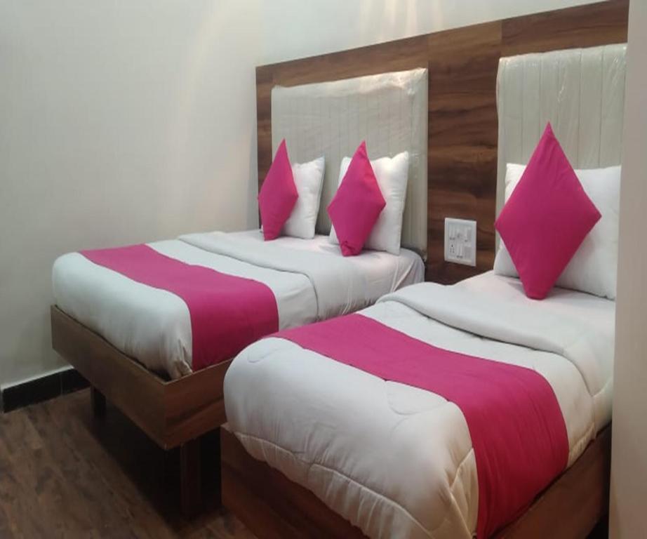 two beds in a hotel room with pink pillows at HOTEL AIR VIEW Near Airport in Mumbai
