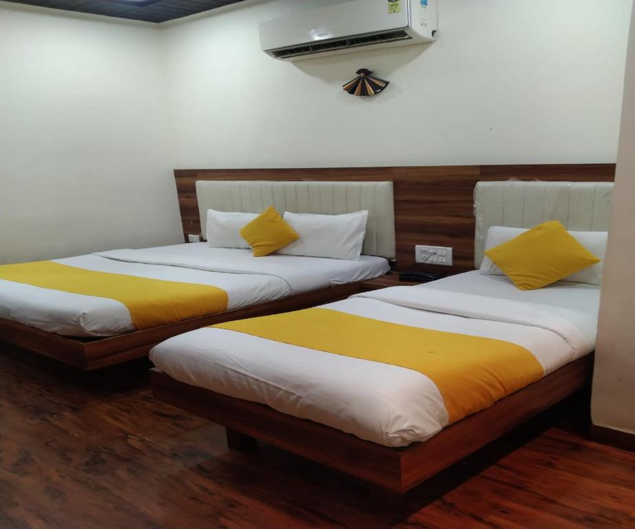 two beds sitting next to each other in a room at HOTEL AIR VIEW Near Airport in Mumbai