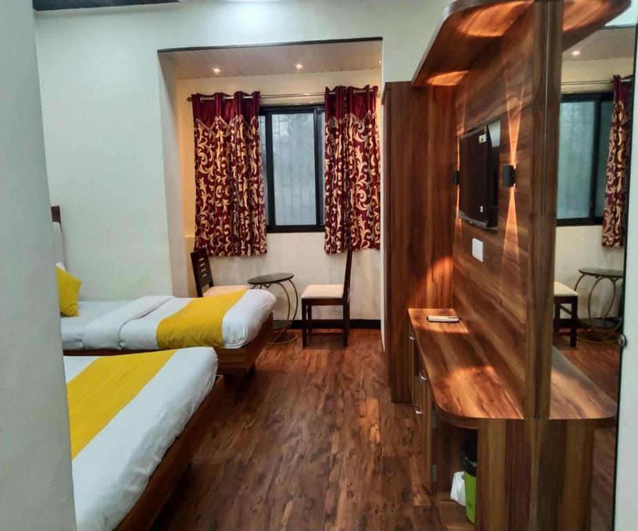 a hotel room with two beds and a desk at HOTEL AIR VIEW Near Airport in Mumbai