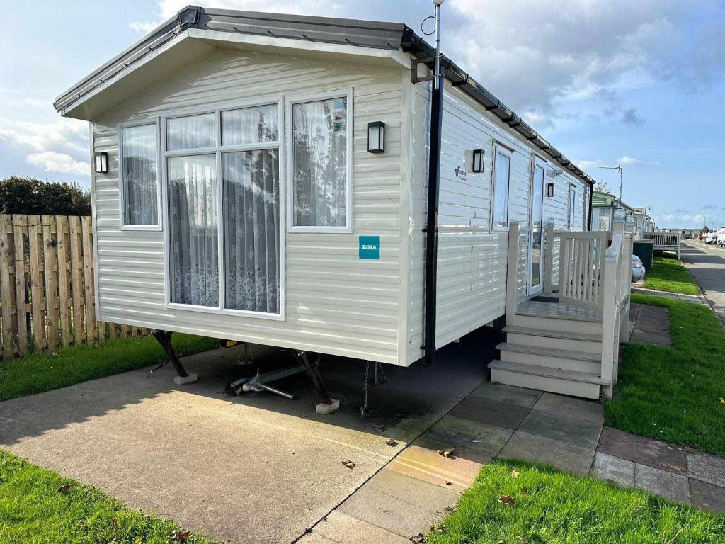 a white tiny house sitting on the side of a street at 6 berth golden sands Rhyl in Kinmel Bay