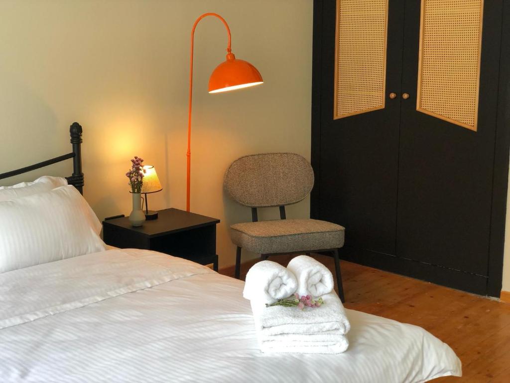 a bedroom with a bed with towels and a chair at Utopia Konak Otel in Bozuyuk