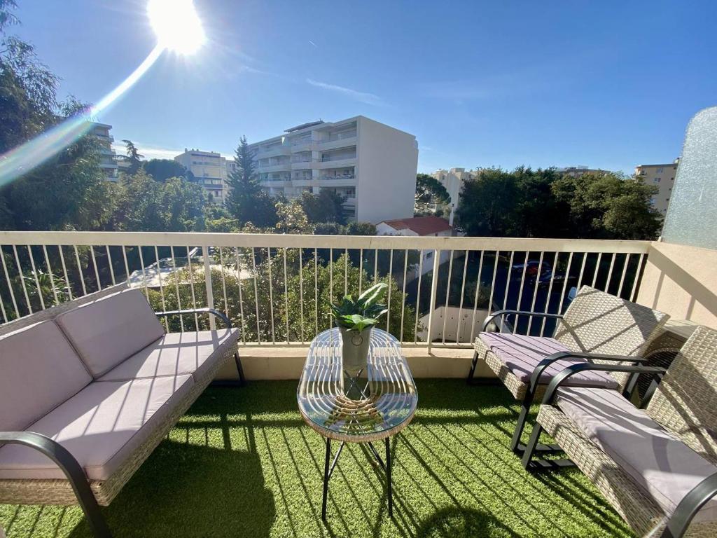 un balcon avec un canapé, une table et des chaises dans l'établissement Cannes proche Croisette - 2P tout confort terrasse, à Cannes