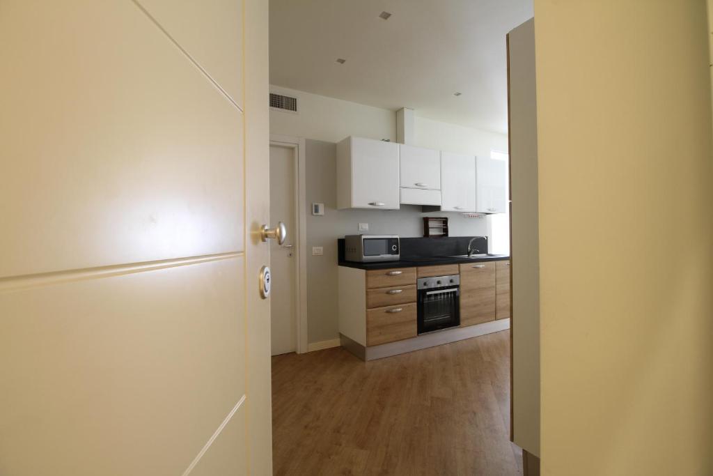 a kitchen with white cabinets and a stove top oven at La Cordata Accommodation - Martinelli 55 - Mono 7 in Rho