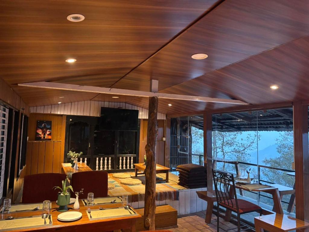 una sala da pranzo con soffitti e tavoli in legno e sedie di Nirvana Resort a Nagarkot
