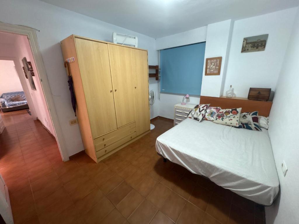 a bedroom with a bed and a wooden cabinet at Wbs in Almería