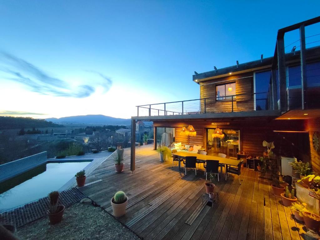 une maison dotée d'une terrasse avec une table et une piscine dans l'établissement Maison contemporaine en bois au coeur des Corbières, à Ferrals-lès-Corbières