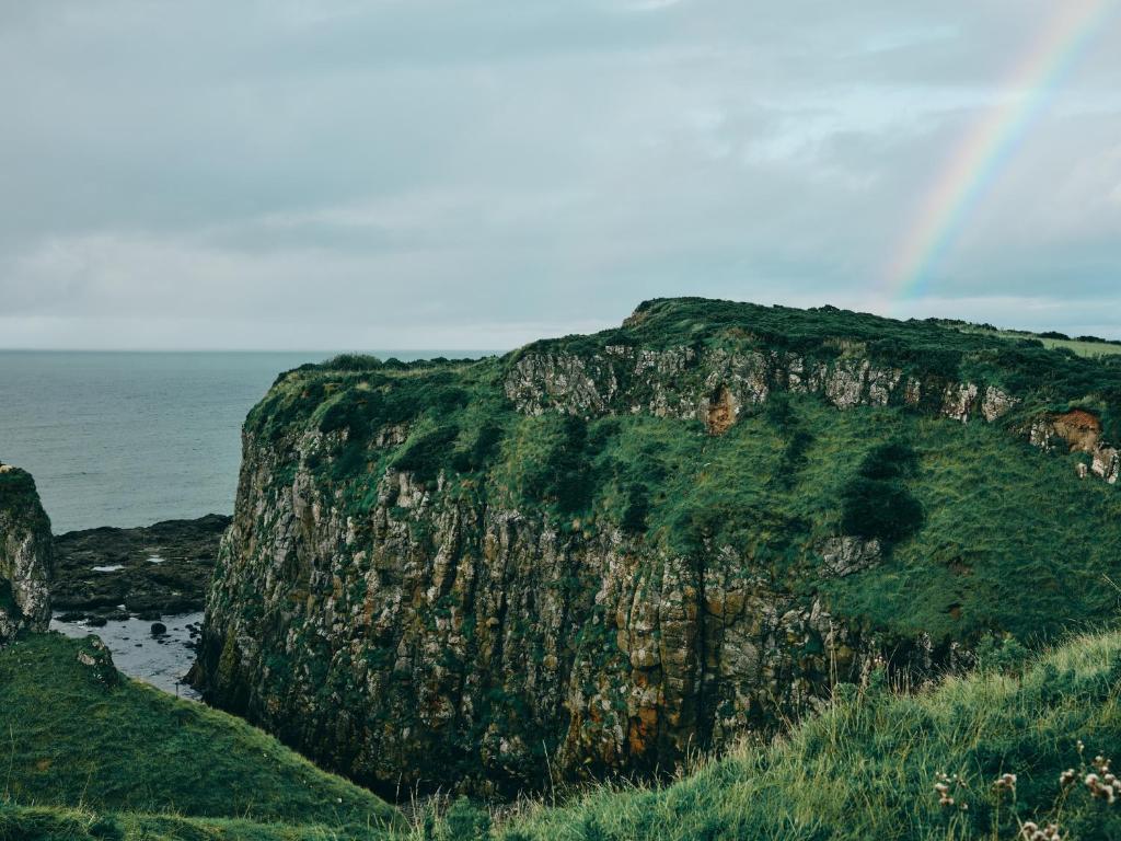 a large rocky cliff next to the ocean at Portrush Adelphi in Portrush