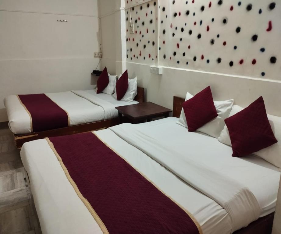 two beds in a hotel room with red and white at HOTEL AIR VIEW Near Airport in Mumbai
