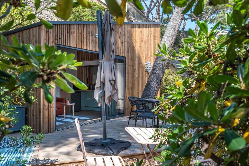 un patio con ombrellone, sedie e un tavolo di La cabane a Narbonne-Plage