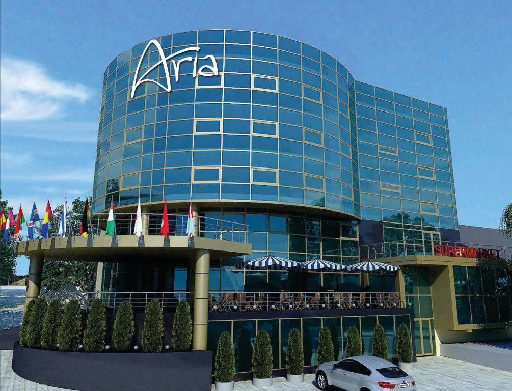 un coche aparcado frente a un gran edificio de cristal en Aria Hotel Chisinau, en Chişinău