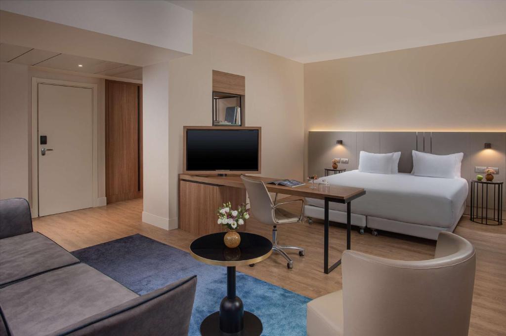 a hotel room with a bed and a television at NH Trieste in Trieste