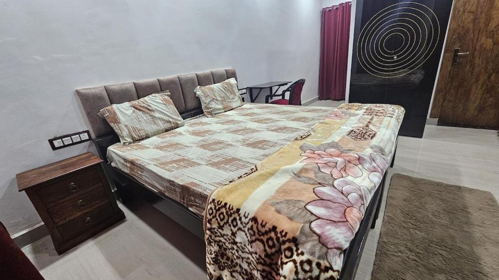 een slaapkamer met een bed en een nachtkastje bij Sukdham Homestays Mathura! in Mathura