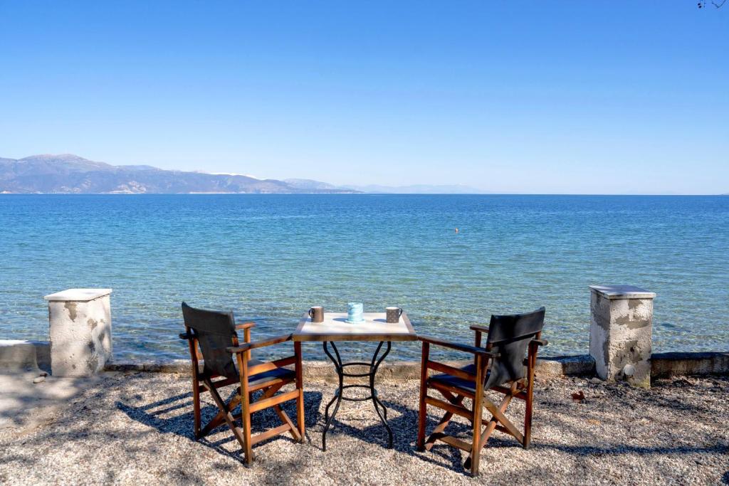 a table and chairs sitting next to the water at The Greek Getaway in Lóngos