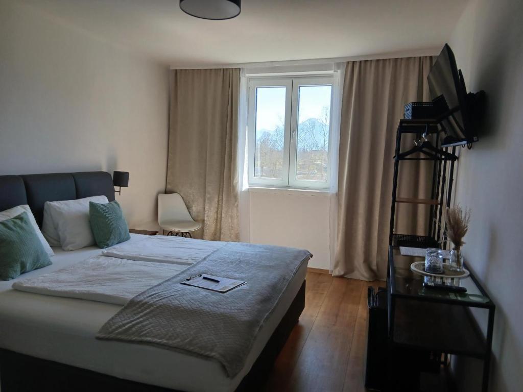 a bedroom with a large bed and a window at Hotel Fuchs & Hase SELF CHECK IN in Rosegg