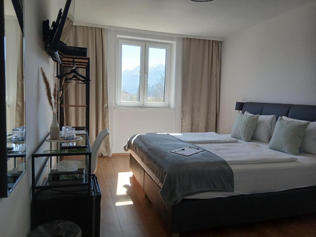 a bedroom with a large bed with a window at Hotel Fuchs & Hase SELF CHECK IN in Rosegg