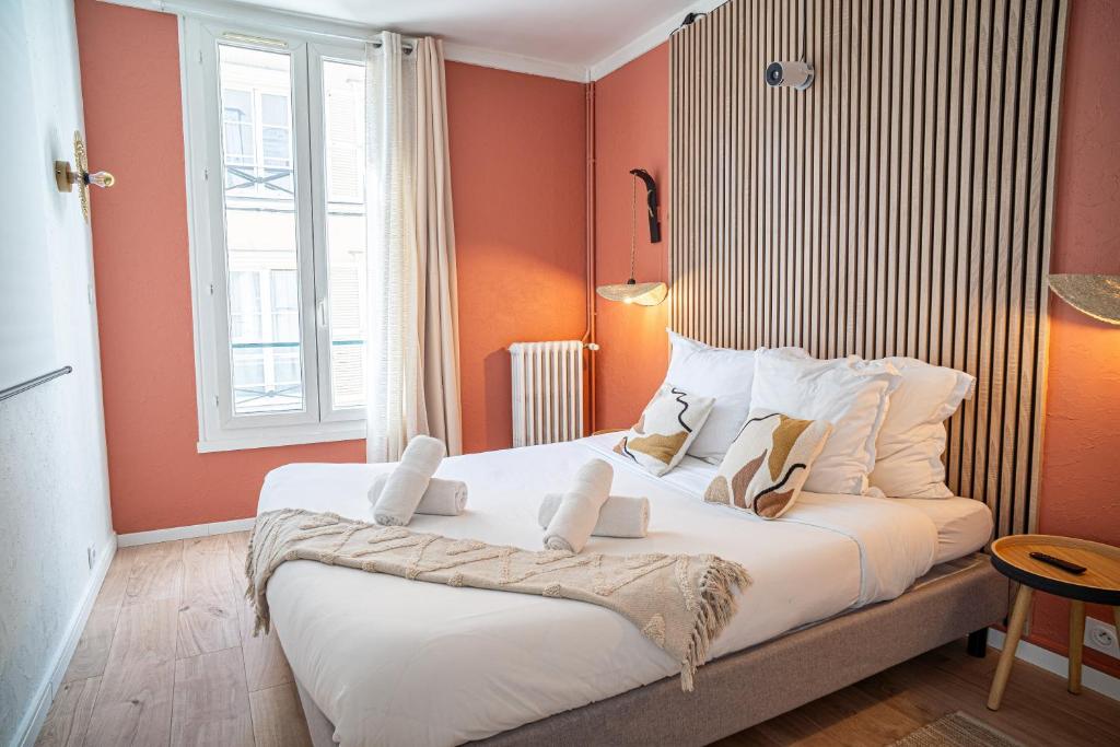 a bedroom with a large bed with orange walls at Hypercentre- Confort Premium - Home Cinéma - Parking facile in Troyes