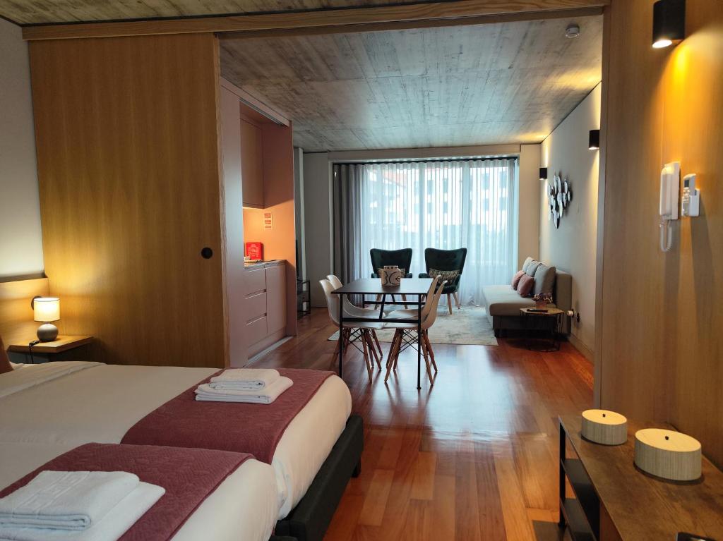 Un dormitorio con una cama y una mesa y sillas. en Fervença Apartments, en Vila Nova de Gaia