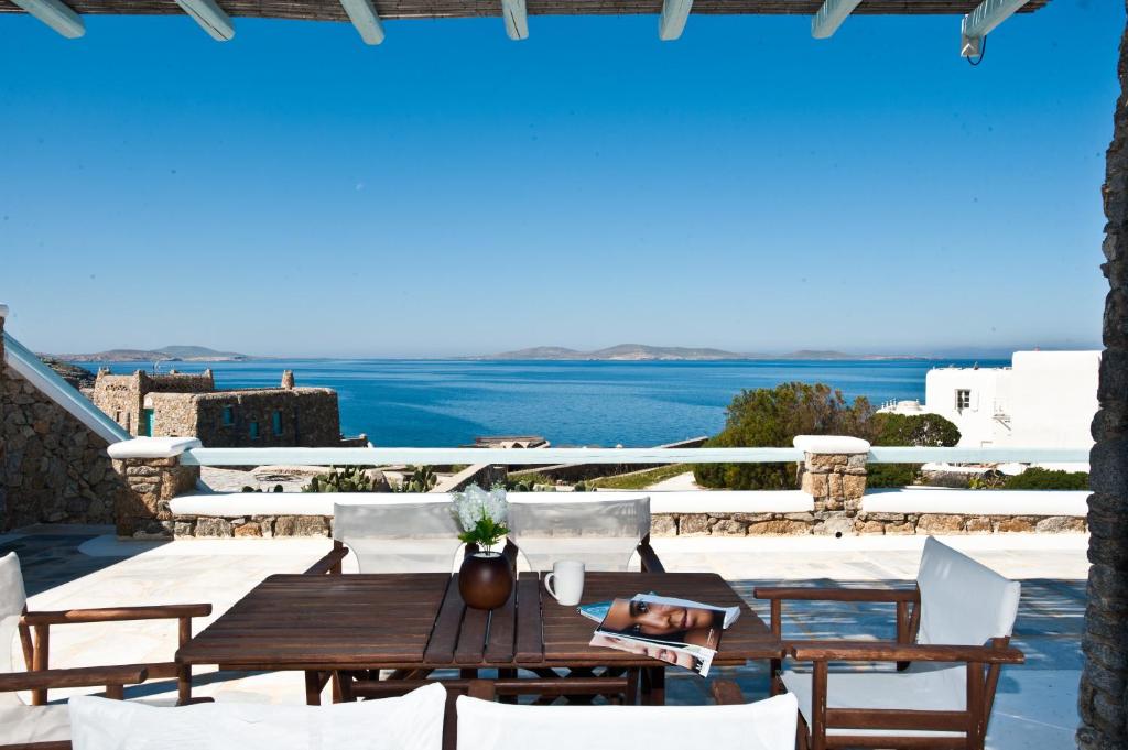 a table on a patio with a view of the ocean at Sofia's Bungalows Mykonos in Mikonos