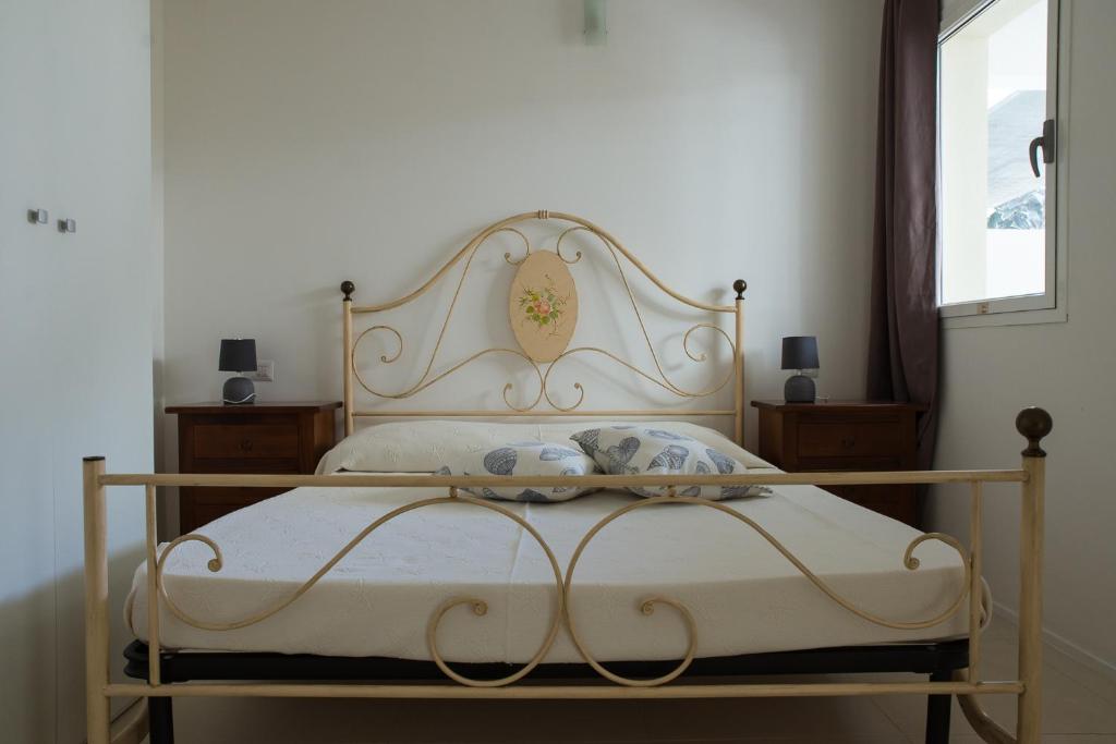 a bedroom with a white bed with a wooden frame at Cormorani appartamento N 5 in Golfo Aranci