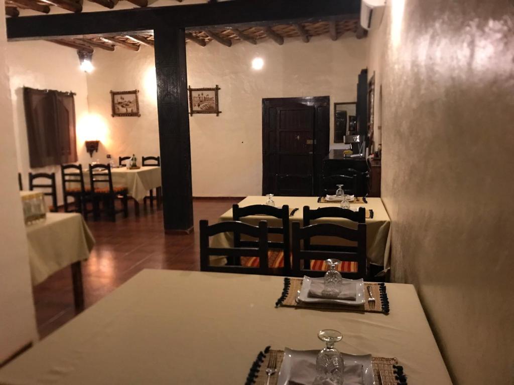 une salle à manger avec des tables et des chaises dans un restaurant dans l'établissement Riad Moha, à Merzouga
