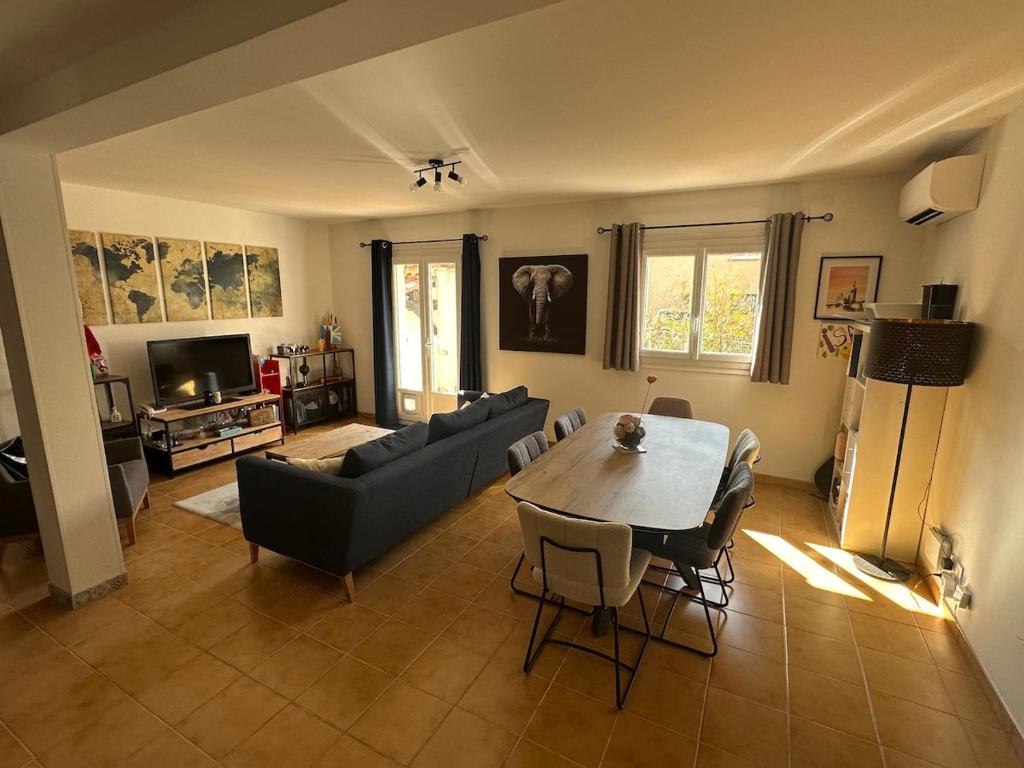 un salon avec une table et un canapé dans l'établissement Maison avec piscine proche plages et commerces, à Fréjus