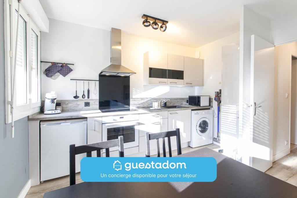 une cuisine avec des armoires blanches et une table et des chaises dans l'établissement Létanduère Wifi Tramway, à Angers