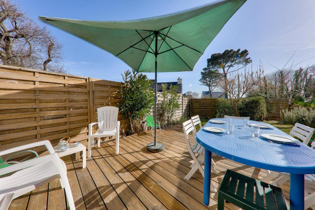 une terrasse avec une table bleue, des chaises et un parasol dans l'établissement Maison pour 5 avec jardin a 300m de la plage, à Sarzeau