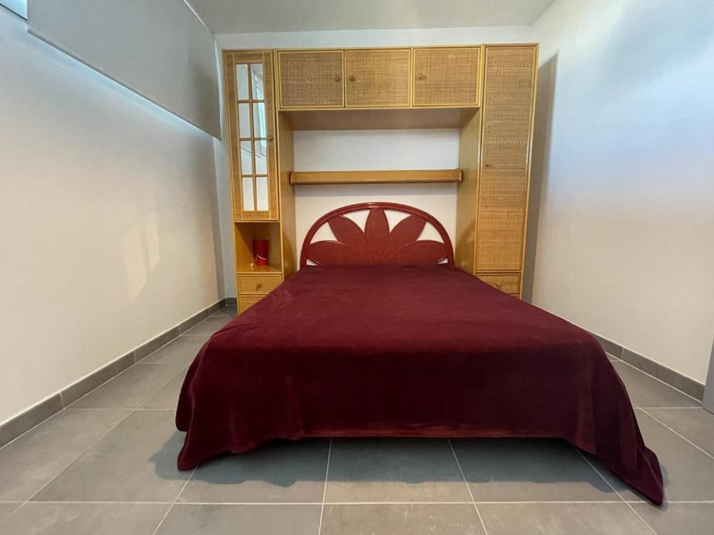 une chambre avec un lit rouge dans une pièce dans l'établissement Appartement 6 personnes Héliopolis - K 204, au Cap d'Agde