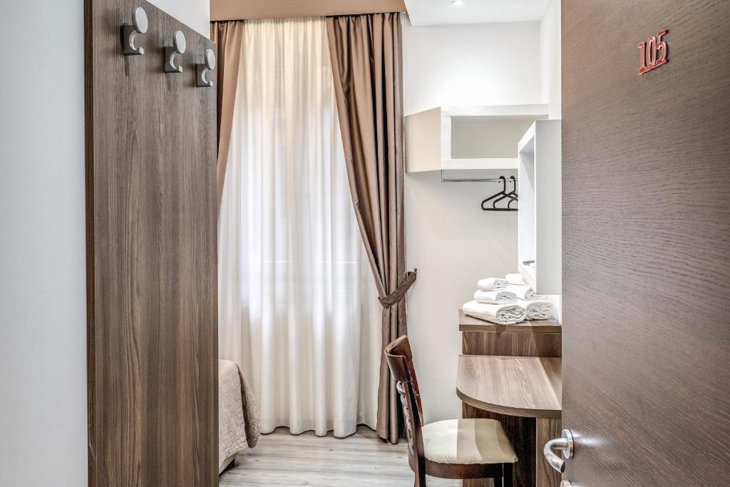 a room with a window with a table and a curtain at Spagna Boutique Suites in Rome