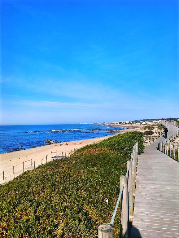 a boardwalk leading to a beach with the ocean at Casa KAD in Vila Nova de Gaia
