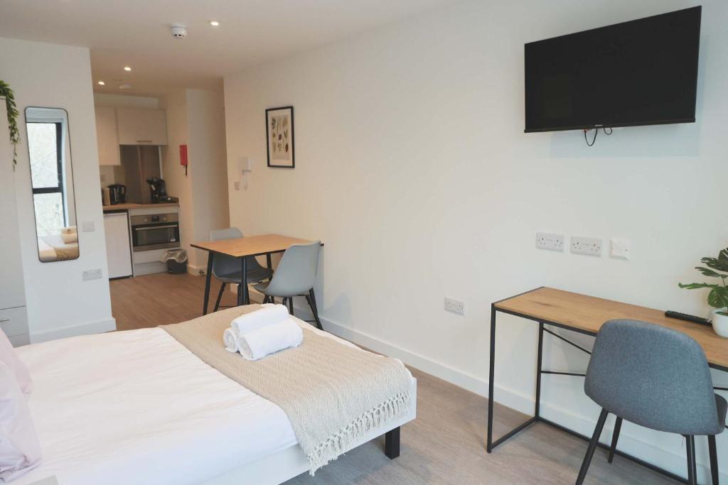 a room with a bed and a desk and a television at Redcross studio flat 312 in Bristol
