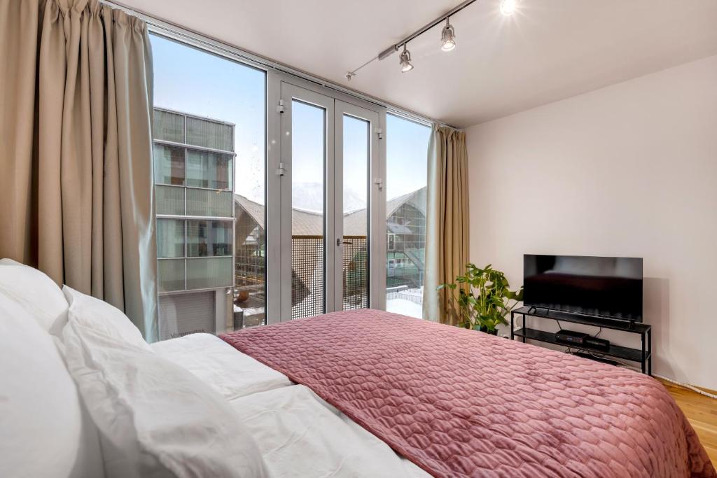 une chambre avec un lit et une grande fenêtre dans l'établissement City Center Apartment, à Tromsø