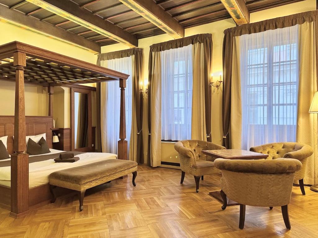 sypialnia z łóżkiem z baldachimem i 2 krzesłami w obiekcie Traditional Prague Apartment w Pradze