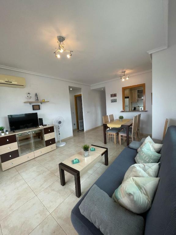 a living room with a blue couch and a table at Apartamento 3 habitaciones en la playa de Magic World , Oropesa del Mar in Cabanes