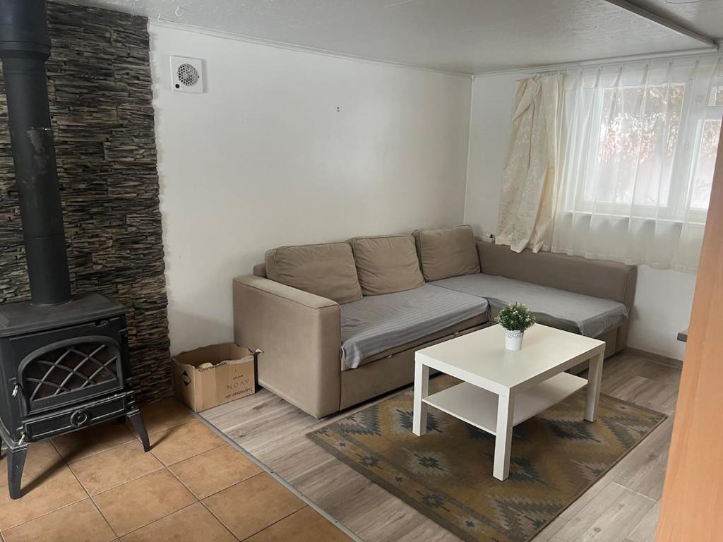 een woonkamer met een bank en een fornuis bij Small house in Vilnius