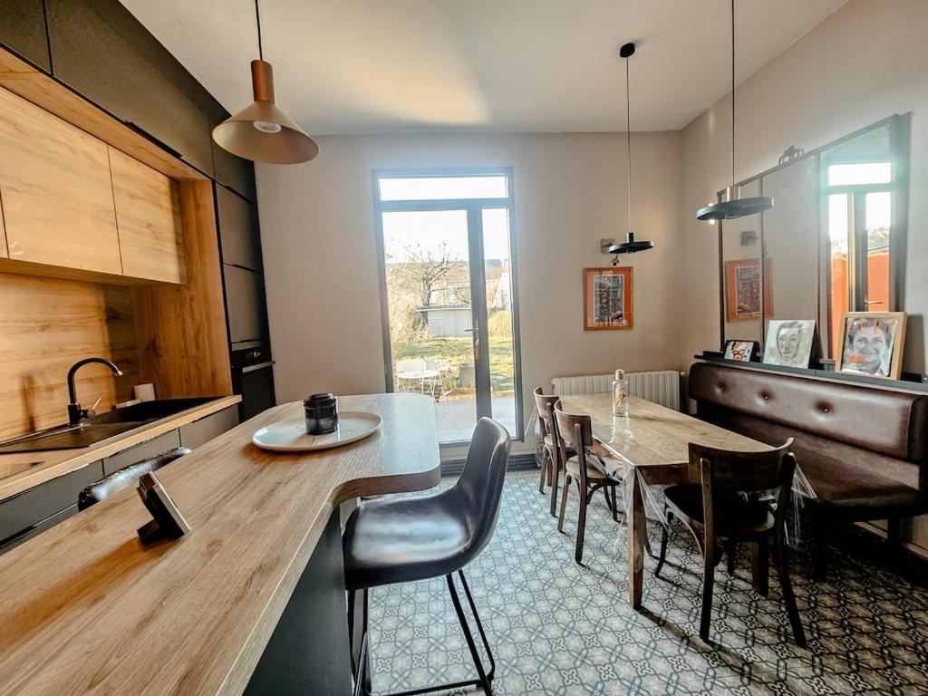 une cuisine et une salle à manger avec une table et des chaises dans l'établissement La Belle Maison, centre ville, 3 chambres et jardin, à Reims