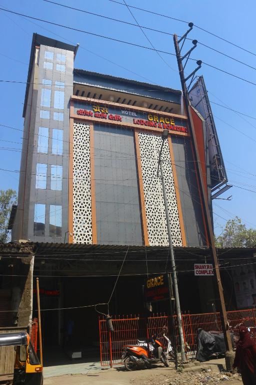 UlhāsnagarHotel Grace Lodging & Boarding的一栋建筑前停着一辆摩托车