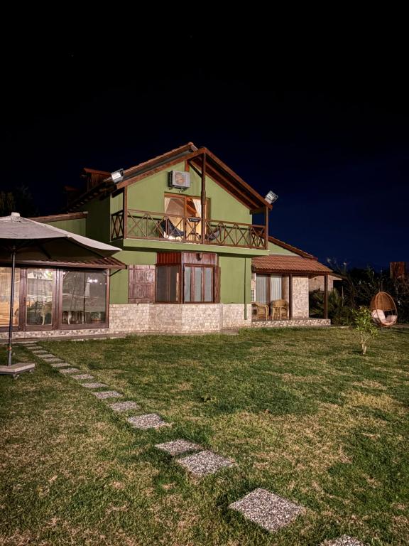 een groen huis met een gazon ervoor bij La Casa Verde Butik Otel in Izmir