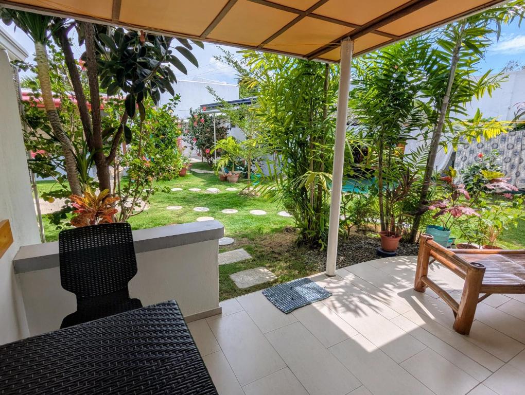 a patio with a table and a bench and trees at Astillo's Guest Houses in Moalboal