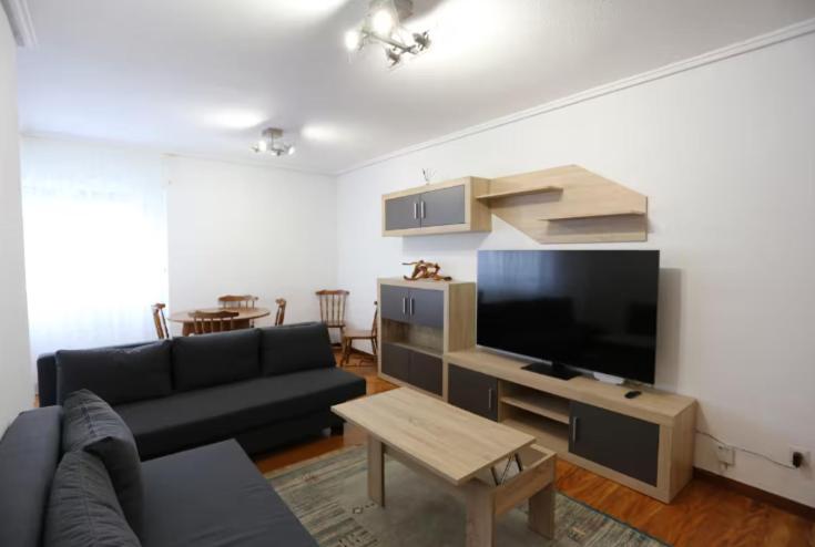 a living room with a couch and a flat screen tv at Tus vacaciones en Noja in Noja