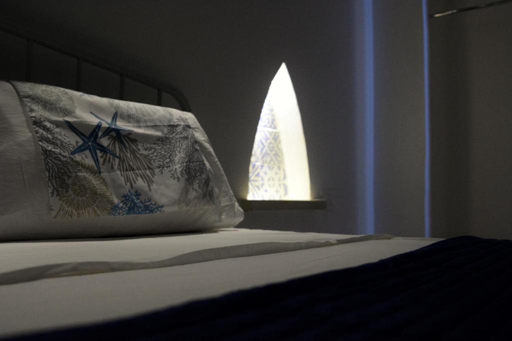 a bedroom with a bed with a pillow and a window at Le Stanze sul Mare in Gallipoli