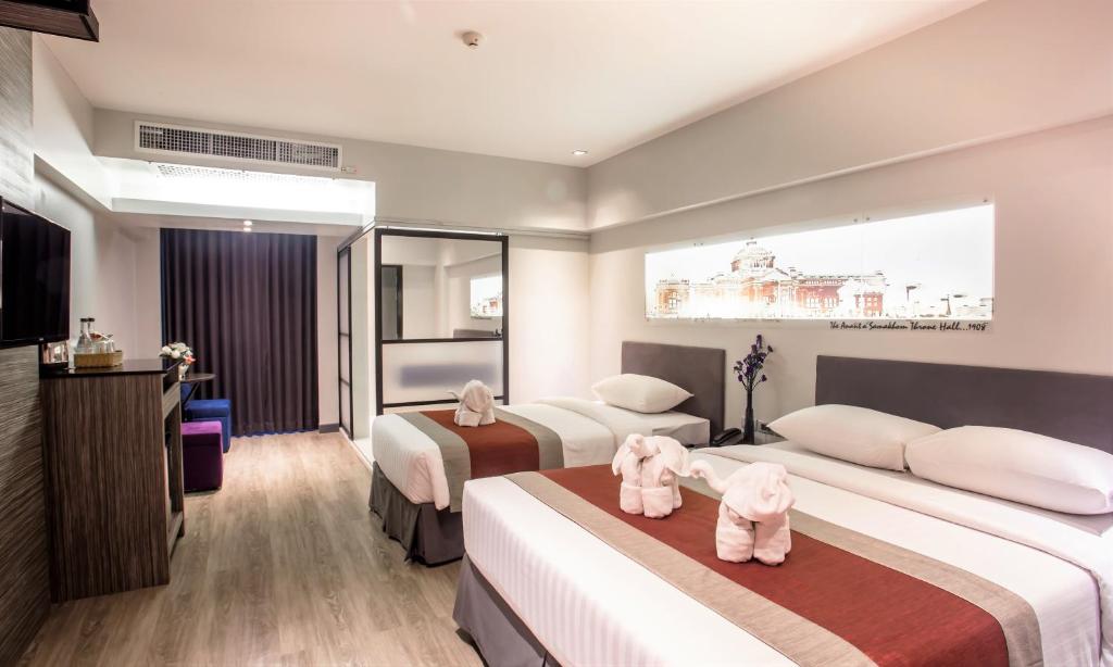 A spacious twin room with two beds, a minibar cabinet and a glass-paneled partition.