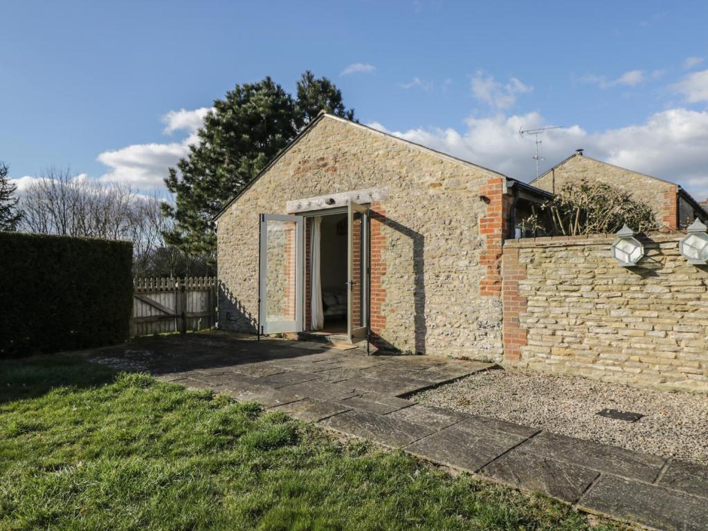 un edificio in mattoni con una porta in un cortile di South Barn Cottage a Faringdon