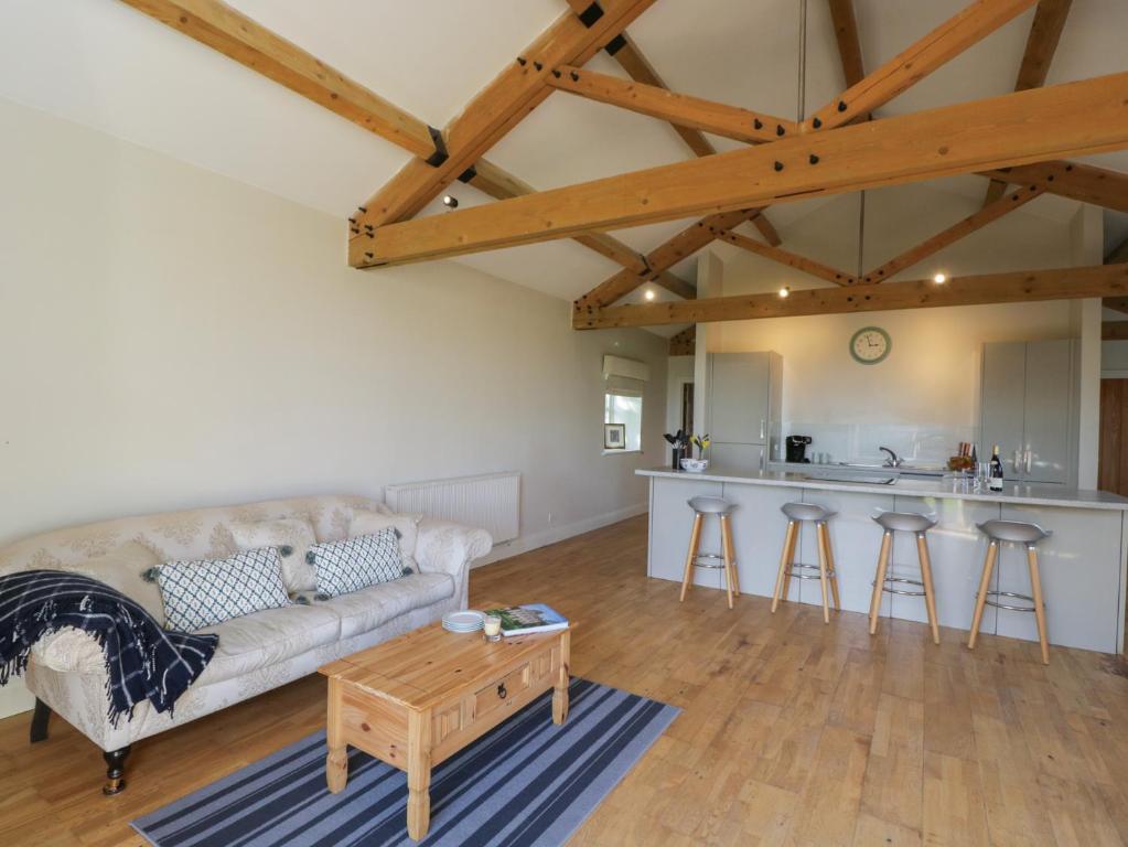a living room with a couch and a table at South Barn Cottage in Faringdon