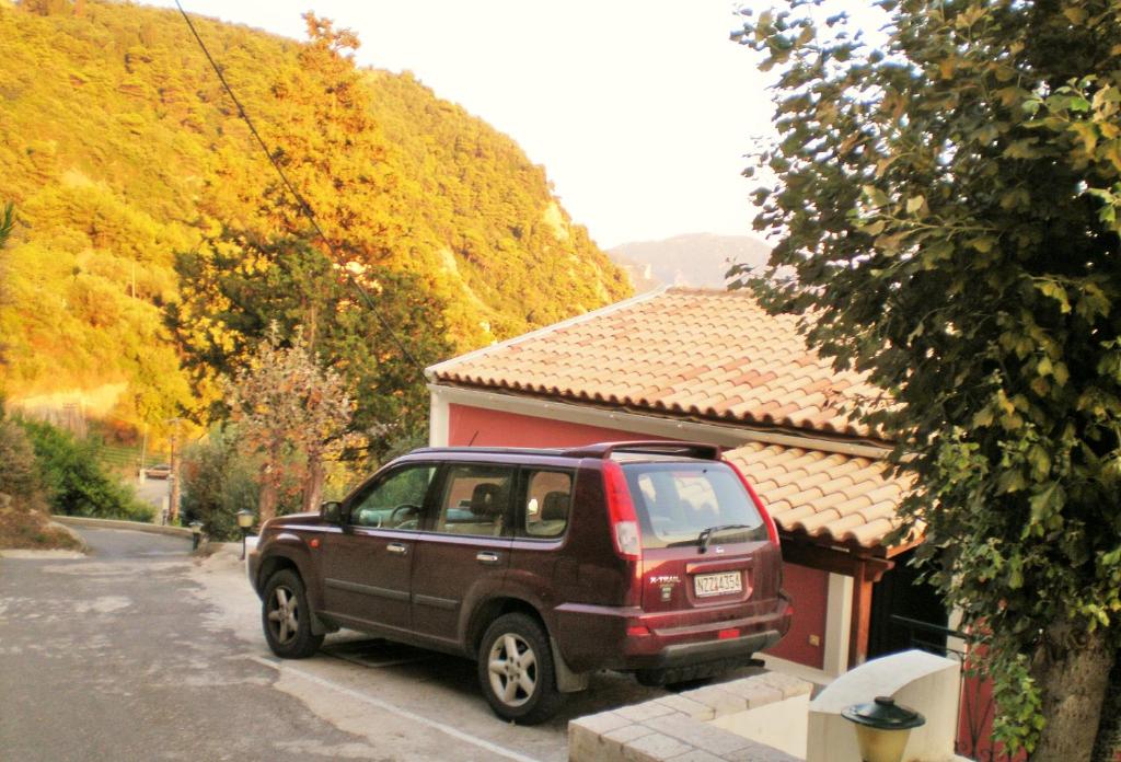 a red truck parked in front of a house at MENIGOS RESORT - Διαμέρισμα Αριθμός 168 in Pelekas