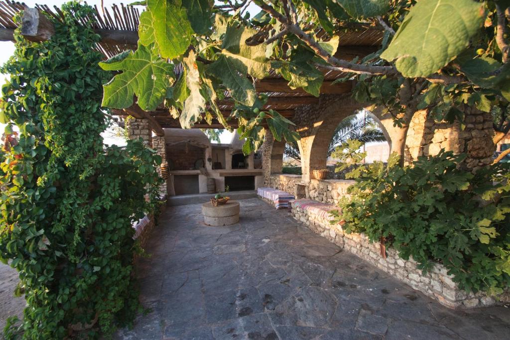 a garden with a stone archway with plants and a bench at Abramis Rooms in Mitáta