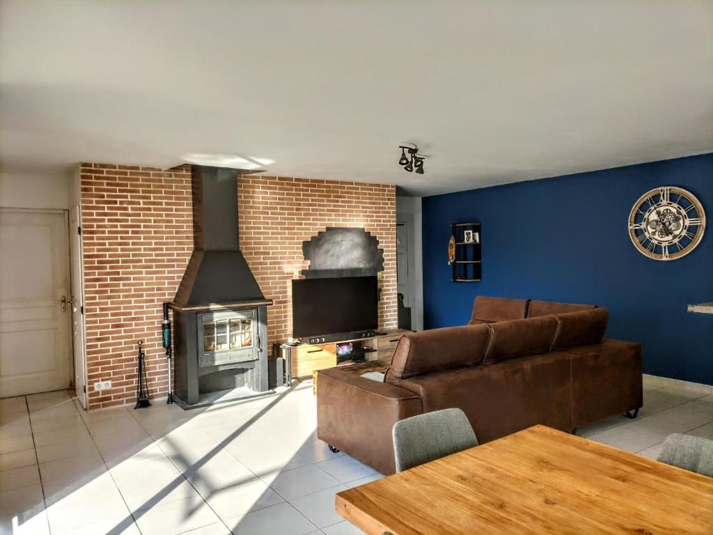 un salon avec un canapé et une cheminée dans l'établissement Maison 100m2 plain pied 3 chambres piscine 2 places Parking, à Gigean