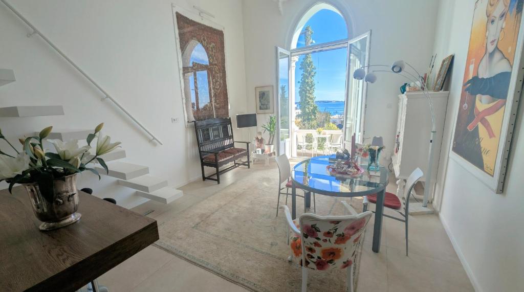 une salle à manger avec une table en verre et une fenêtre dans l'établissement Ref MAURESQUE by Palmes d Or Properties, au Golfe-Juan