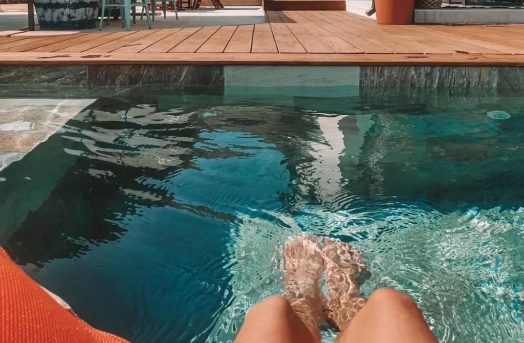 une personne se baignant dans une piscine avec ses pieds dans l'eau dans l'établissement Jolie villa Bali-style, à Marseille